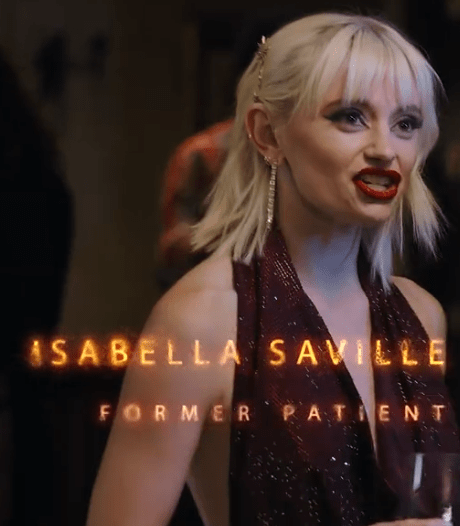 A woman with blonde hair in a glamorous outfit, speaking at an event, with the text 'Isabella Saville, Former Patient' displayed across the bottom.