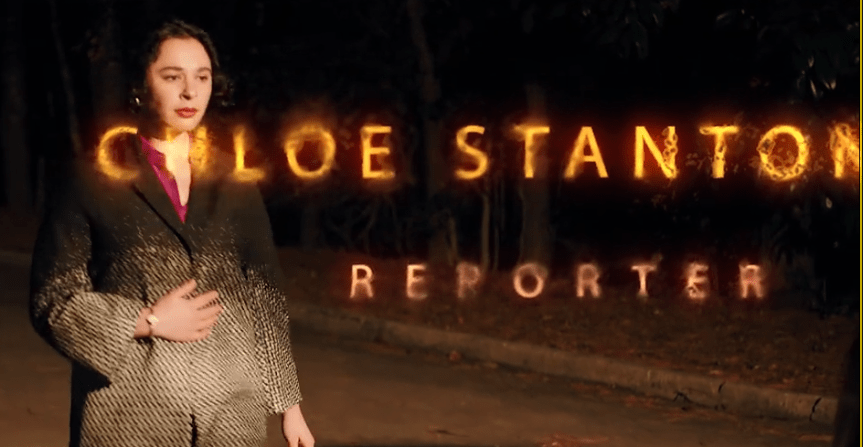 A woman in a stylish suit stands outdoors, with a glowing text overlay that reads 'Chloe Stanton, Reporter.' The background is dark, suggesting a night setting.